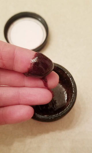 Dark beauty product sample on finger