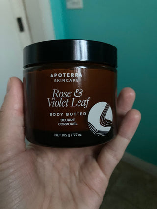 Apoterra Rose & Violet Leaf Body Butter jar held in hand