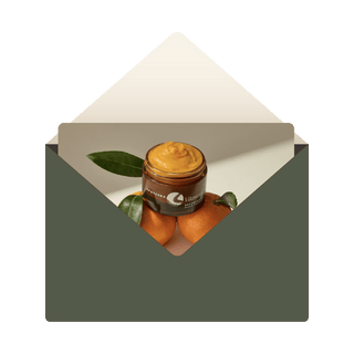 Green envelope with card picturing Vitamin C Balm balanced on oranges