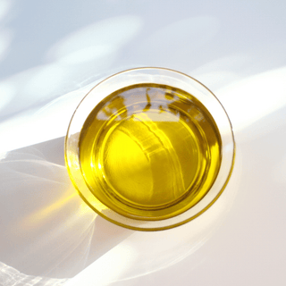 Olive oil in a glass bowl, close-up.