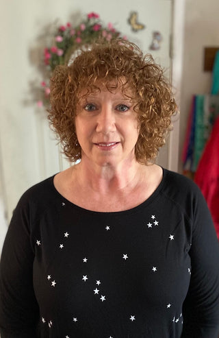 Woman with curly hair and star shirt