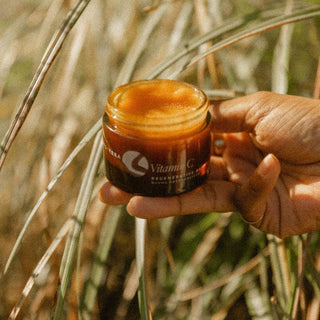 Hand holding a jar of best-selling Vitamin C balm 