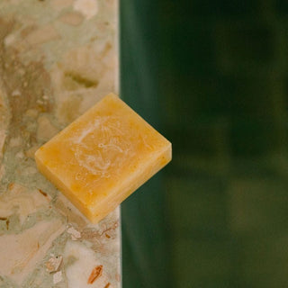 Pumpkin and Wild Carrot Brightening Facial Soap lifestyle image featuring soap resting on the edge of a marble counter