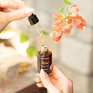 Apoterra Rose Nourishing Facial Oil bottle and dropper showing rose oil near flowers