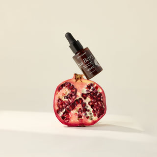 Sea Berry Balancing Facial Oil balancing on a pomegranate in a still life image